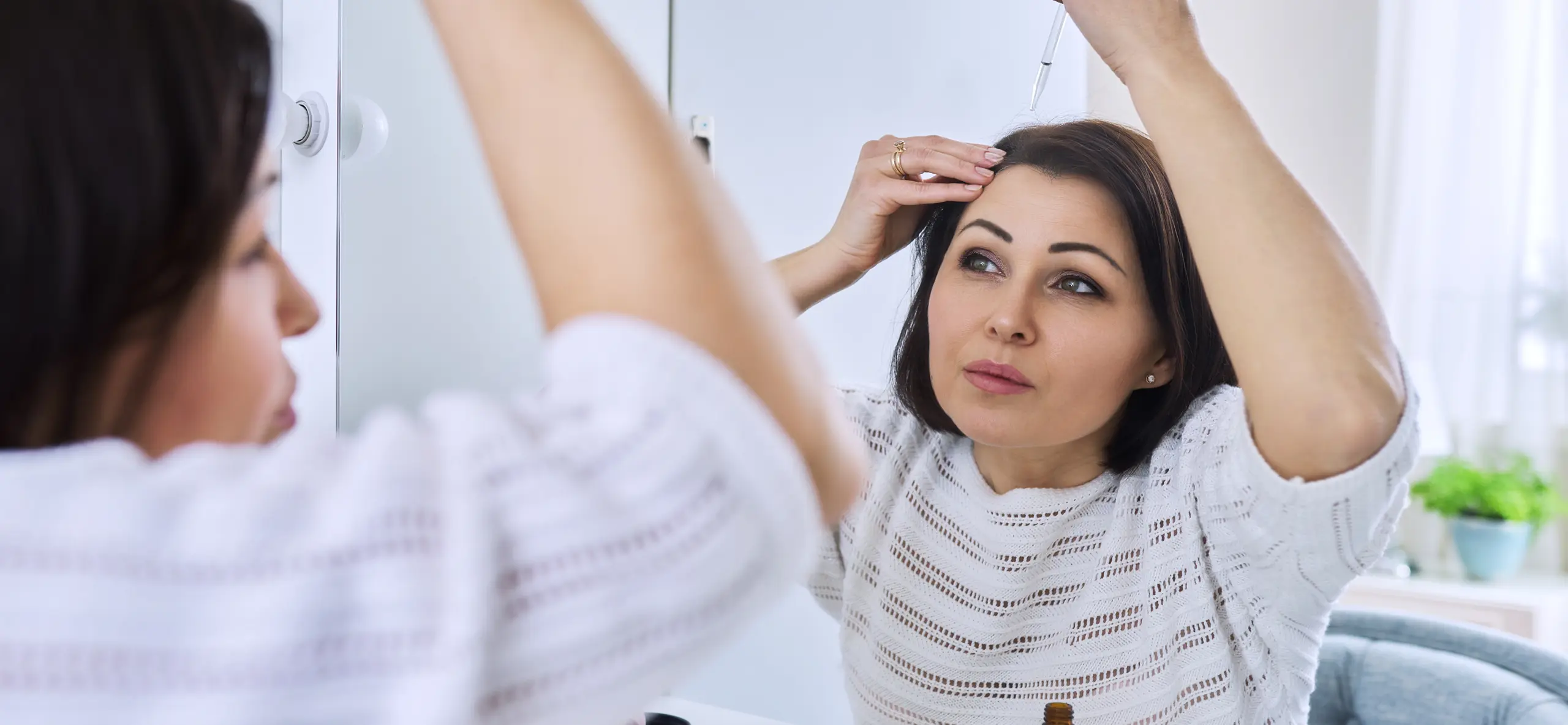 Woman checking hair in mirror